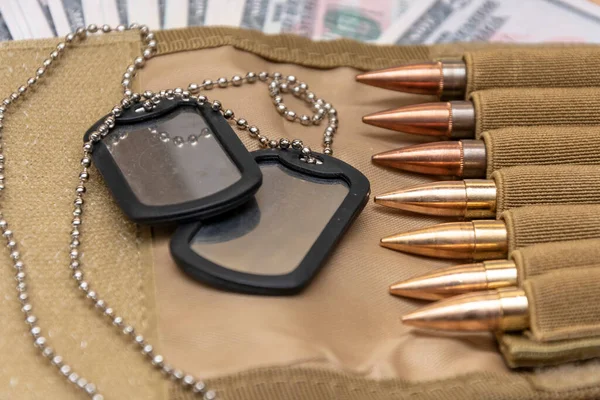 Amerikan doları banknotlarında ordu kimlik madalyonları, gerçek cephanesi olan bandocular. Konsept: Askeri özel operasyon, silah malzemeleri, savaşın finansmanı, kiralama, silah satışı, askeri emeklilik maaşı, orduda maaş, sigorta
