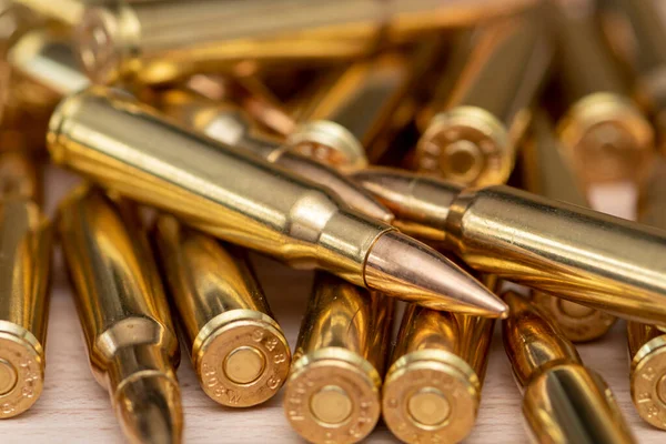 Kalaşnikof taarruz tüfeği için 7.62 kalibrelik mermilerin etrafa saçılması, yakın plan, seçici odaklanma. Konsept: ödünç verilmiş silah satışı, mühimmat yardımı, silah tedariği.