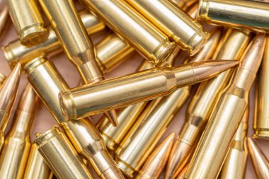 Kalaşnikof taarruz tüfeği için 7.62 kalibrelik mermilerin etrafa saçılması, yakın plan, seçici odaklanma. Konsept: ödünç verilmiş silah satışı, mühimmat yardımı, silah tedariği.