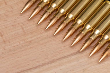 Kalaşnikof saldırı tüfeği için 7.62 kalibrelik mermili bir sıra. Arka planda, yakın plan, seçici odaklanma. Konsept: ödünç verilmiş silah satışı, silah ve mühimmat yardımı, silah tedariği.