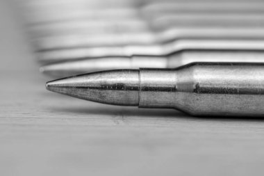 Kalaşnikof saldırı tüfeği için 7.62 kalibrelik mermili bir sıra. Arka planda, yakın plan, seçici odaklanma. Konsept: ödünç verilmiş silah satışı, silah ve mühimmat yardımı, silah tedariği.