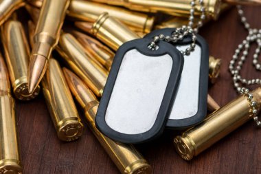 Ordu kimlik belgeleri dağınık sarı makineli tüfek fişeklerinin üzerinde duruyor, seçici odaklanma. Kavram: Askeri özel operasyon, Ukrayna 'da savaş, askere alma, askeri operasyonlar.