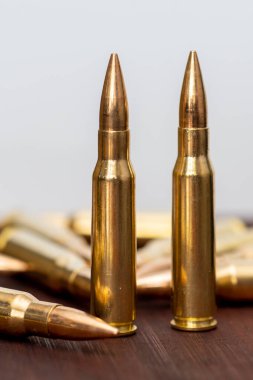 Dağıtılmış fişekler ve Kalaşnikof saldırı tüfeği için 7.62 kalibrelik mühimmat yakın plan, seçici odaklanma. Konsept: silah satışı ve tedariği, askeri yardım.