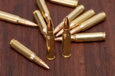 Dağıtılmış fişekler ve Kalaşnikof saldırı tüfeği için 7.62 kalibrelik mühimmat. Arka planda, yakın plan, seçici odaklanma. Konsept: silah satışı ve tedariği, askeri yardım.