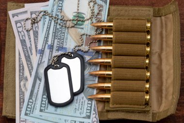 Amerikan doları banknotlarında ordu kimlik madalyonları, gerçek cephanesi olan bandocular. Konsept: Askeri özel operasyon, silah malzemeleri, savaşın finansmanı, kiralama, silah satışı.