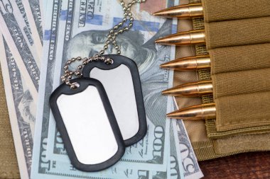 Amerikan doları banknotlarında ordu kimlik madalyonları, gerçek cephanesi olan bandocular. Konsept: Askeri özel operasyon, silah malzemeleri, savaşın finansmanı, kiralama, silah satışı.