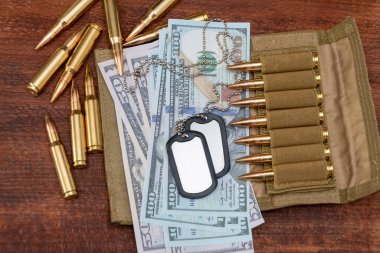 Amerikan doları banknotlarında ordu kimlik madalyonları, gerçek cephanesi olan bandocular. Konsept: Askeri özel operasyon, silah malzemeleri, savaşın finansmanı, kiralama, silah satışı.