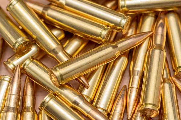 Kalaşnikof taarruz tüfeği için 7.62 kalibrelik mermilerin etrafa saçılması, yakın plan, seçici odaklanma. Konsept: ödünç verilmiş silah satışı, mühimmat yardımı, silah tedariği.