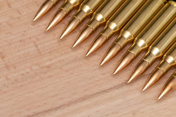 Kalaşnikof saldırı tüfeği için 7.62 kalibrelik mermili bir sıra. Arka planda, yakın plan, seçici odaklanma. Konsept: ödünç verilmiş silah satışı, silah ve mühimmat yardımı, silah tedariği.