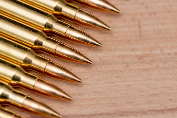 Kalaşnikof saldırı tüfeği için 7.62 kalibrelik mermili bir sıra. Arka planda, yakın plan, seçici odaklanma. Konsept: ödünç verilmiş silah satışı, silah ve mühimmat yardımı, silah tedariği.