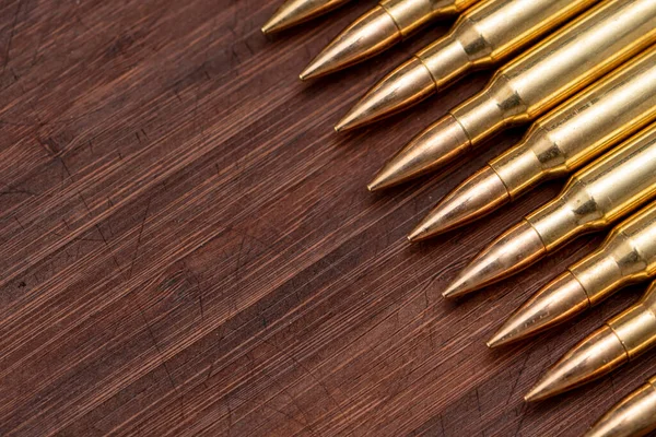 Kalaşnikof saldırı tüfeği için 7.62 kalibrelik mermili bir sıra. Arka planda, yakın plan, seçici odaklanma. Konsept: ödünç kiralanan silahların satışı, silah yardımı