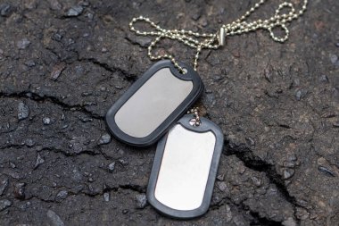 Asfalt arka planında çatlak olan askerlerin ordu kimlik kartları. Kavram: sözleşmeli askerlik, Ukrayna 'da seferberlik, personel kayıpları, kimlik kayıpları.