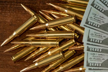 Sarı kartuşlar ve 100 dolarlık banknotlar, yakın plan, seçici odaklanma. Konsept: Kiralık silah satışı, silahlara yardım, orduda iş, cephane ticareti