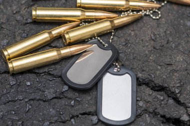 Kırık asfaltın dokulu arka planında askeri kartuşlar ve ordu kimlik belgeleri var..