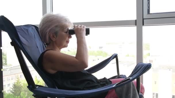 Elderly Woman Sitting Chair Window Watching Street Binoculars Concept Spying — Stockvideo