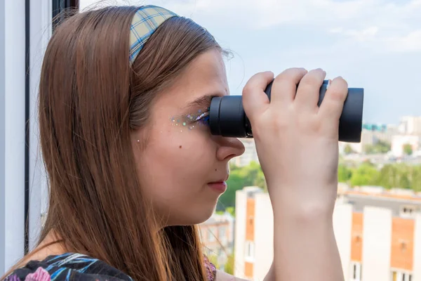 Pencereden genç bir kız sokağı ve komşu evleri dürbünle izliyor. Konsept: komşuları gözetlemek, bilgi toplamak, casusluk ve dedikodu, damadı gözetmek..