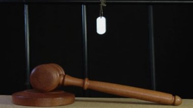 Hakim ahşap bir hakimin çekiciyle mahkumun hücre parmaklıklarının arkasına vuruyor ve bir ordu kimlik kartı asılıyor. Kavram: bir asker ya da askerin yargılanması, hüküm, suçluluk 