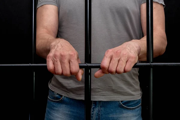 独房の男はバーに手を置いた 裁判所の囚人 有罪判決を受けた人への裁判所の判決 刑務所の用語 — ストック写真