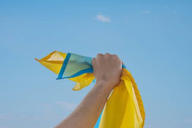 Ukrayna bayrağını tutan bir adam elini kaldırır. Kavram: Ukrayna 'da özgürlük ve ülkenin bağımsızlığı için savaş.