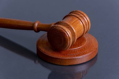Karanlık bir arka planda tahtadan yargıç tokmağı. Konsept: tazminat talebi ve tazminatı, mahkeme oturumu, karar duyurusu, duruşma.