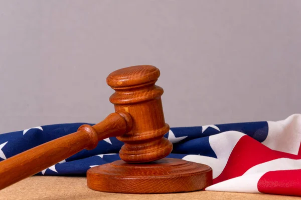 Wooden judge\'s gavel on the background of the Wooden judge\'s gavel on the background of the American flag, a place for text, copy space. Concept: claim and compensation for damages, court session.