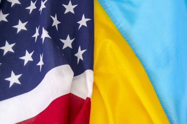 Ukrayna bayrağı ve Amerika bayrağı birbirine bağlıdır, yakın plan, bayraklar üzerinde kıvrımlar ve dalgalar. Konsept: Ortak toplantı, Ödünç Kiralama yardımı.