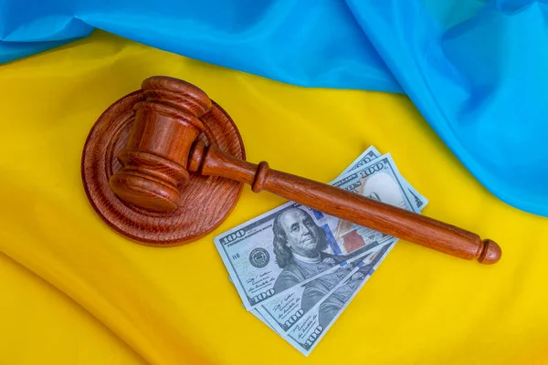 Judicial gavel, Ukrainian flag, 100-dollar banknotes. Concept: corruption in court, bribery, a court fine and a lawsuit.