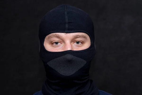 一个身披巴拉克拉瓦的严肃男人的画像他脸上的黑色面具掩盖了他的外表也许他是个罪犯或者是个黑客或者是个狙击手 — 图库照片