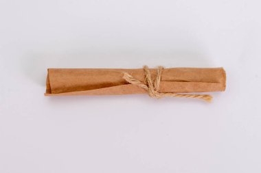 Yuvarlanmış eski kağıt nota, hafif arka planda dokulu iple bağlanmış, seçici odaklı..