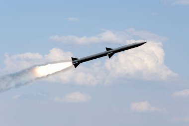 Bir savaş roketi bulutların üzerinde uçuyor, roketten duman ve ateş yükseliyor. Konsept: Füze saldırısı, hava saldırısı, Rusya ile Ukrayna arasındaki savaş, füze saldırısı.