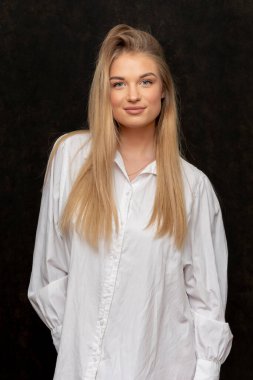 20-25 yaşlarında, siyah desenli beyaz gömlekli güzel bir sarışın..