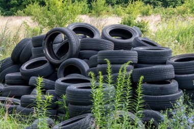 Old car tires, worn-out car tire tread, a dump of used tires from used cars. Environmental pollution.
