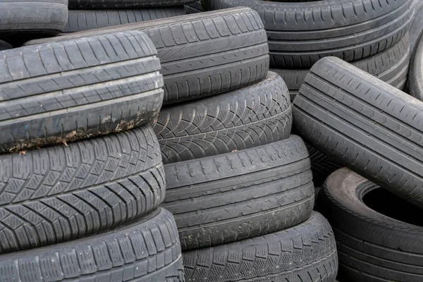 Old car tires, worn-out car tire tread, a dump of used tires from used cars. Environmental pollution.