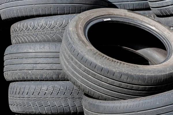 Old car tires, worn-out car tire tread, a dump of used tires from used cars. Environmental pollution.
