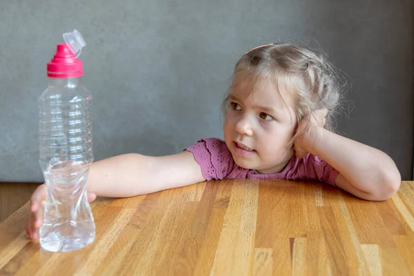 Beautiful Blonde Girl Years Old Sitting Table Holding Plastic Bottle — Stock fotografie