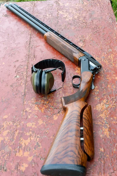 Sports Double Barreled Shotgun Headphones Shooting Lie Wooden Table — Stok fotoğraf