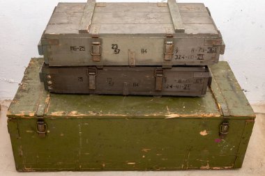 A stack of old wooden military green boxes with ammunition of the Soviet army.