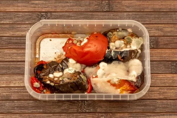 Moldy vegetables in a plastic food container for food.