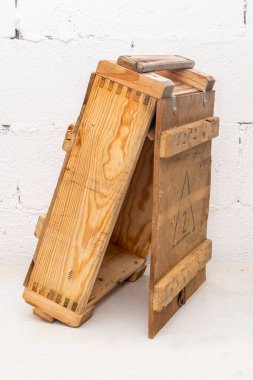 An open wooden box with Russian cartridges and ammunition on a light textured background.