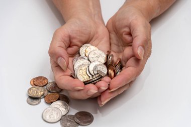 A handful of small coins in his hands on a white background. Concept: small pension, poverty, lack of money for living,