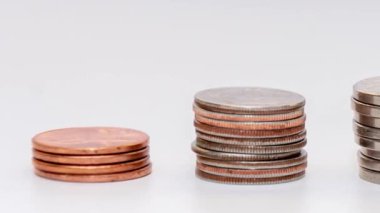stop motion reduces a stack of coins on a white background, camera movement. Concept: falling incomes, financial crisis.