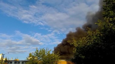 There is a fire in the building, the roof and upper floors are burning, black smoke rises up. Concept: fire safety in case of natural disasters, hit by a projectile or a bomb.