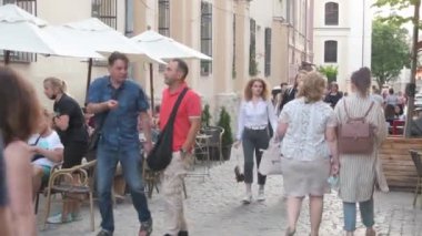 Şehirde dolaşan kalabalıklar, yazlık açık kafelerde oturan turistler, yayalar, Ukrayna, Lviv, 20 Temmuz 2021.