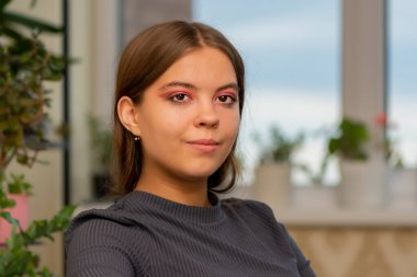 19-20 yaşlarındaki güzel bir kızın portresi. Pencerenin önündeki bir odada..