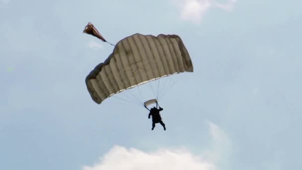 青い空と雲を背景に 軍用パラシュートが降下します コンセプト 航空機の着陸 ウクライナでの戦争 特殊部隊 — ストック動画