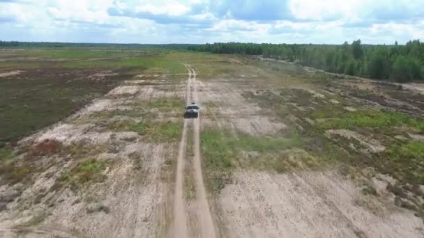 Military Camouflaged Passenger Car Driving Dirt Road Forests Fields Aerial — Stock Video