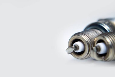 Yaratıcı soyut araba onarım hizmeti ve otomotiv sektörü iş konsepti: beyaz arka planda izole edilmiş metal bujilerin makro görünümü ve seçici odak etkisi