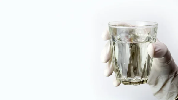 Sarung tangan memegang segelas air — Stok Foto