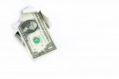 Jeden dolar trčí z díry na bílém pozadí, neúplný příjem.