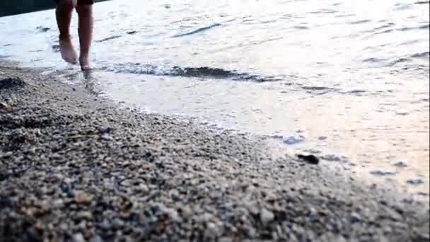 Dziecko spaceruje boso po plaży w falach wody, masaż stóp relaks. — Wideo stockowe